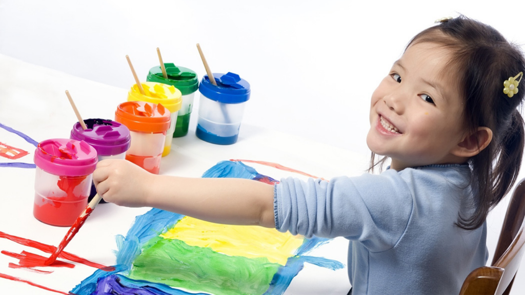 preschool girl painting with multiple colors