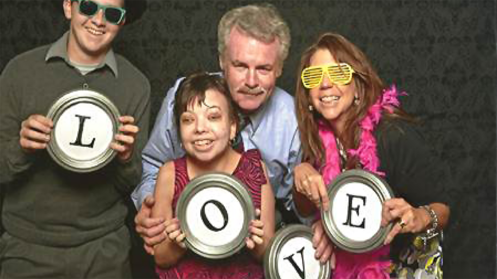 Family having fun in photo with props spelling out LOVE