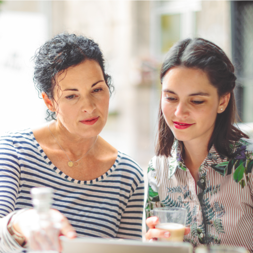 two dark haired women at an outside table