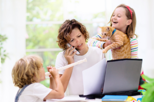 Busy mom trying to work while two busy kids distract her