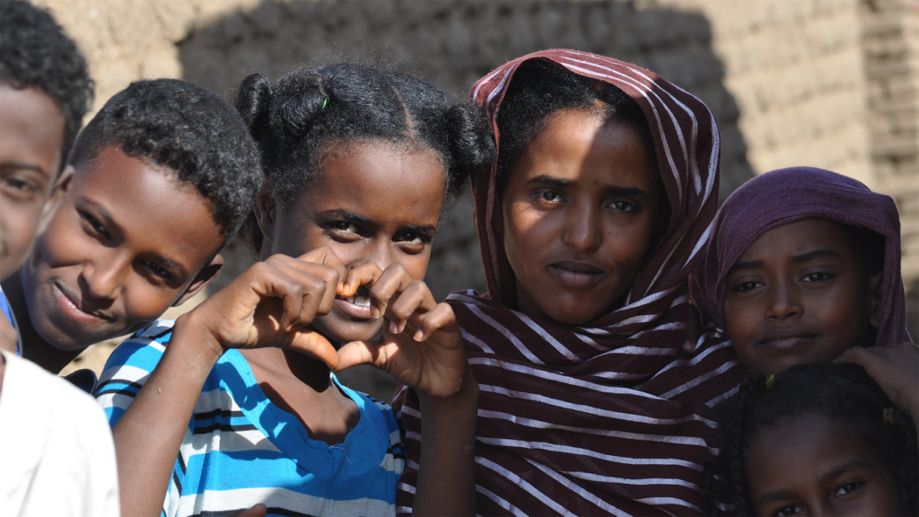 Young dark skinned children one girl making a heart with her hands