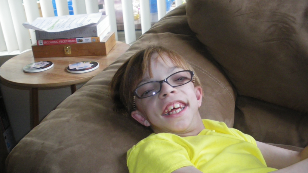 smiling tween girl laying on sofa