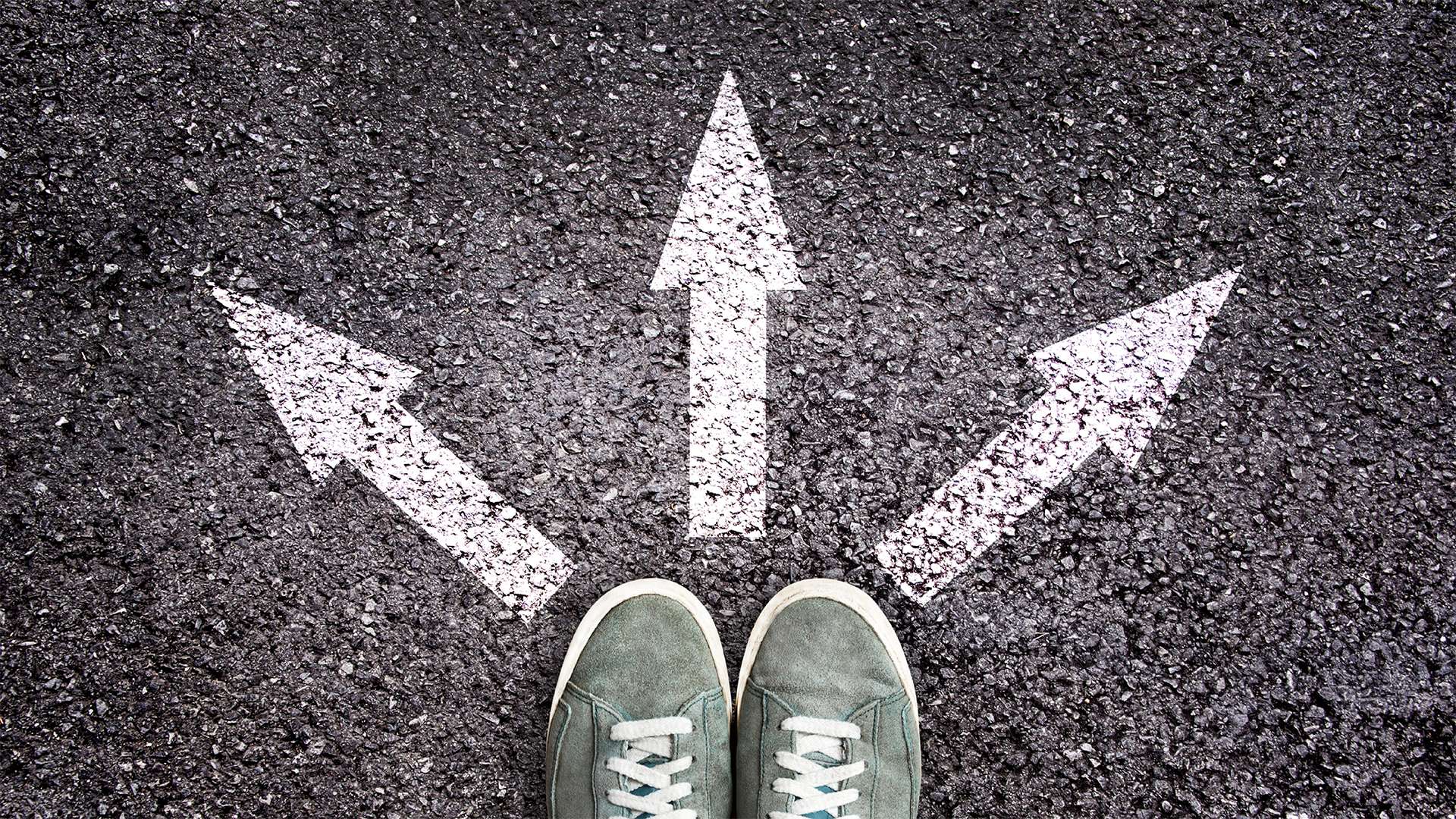 view looking down on two on a street with three arrows pointing in different directions