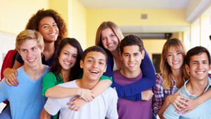 group of high school students giving piggy back rides in school corridor