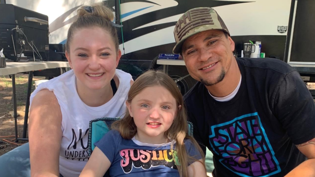 Mother, daughter and father smiling at the camera