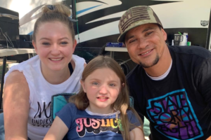 Mother, daughter and father smiling at the camera